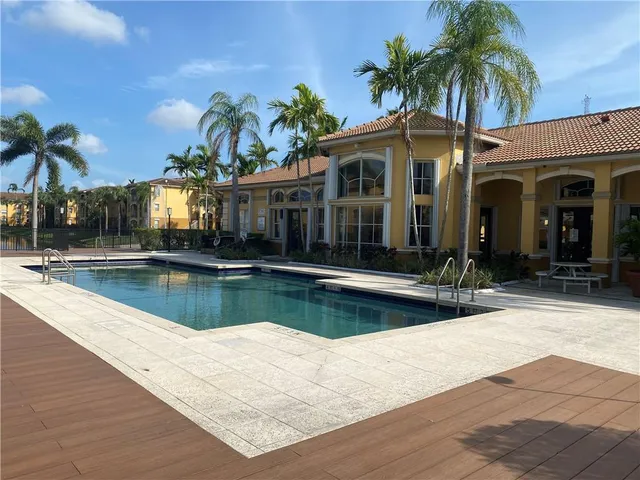 a view of a swimming pool with a lawn chairs under an umbrella