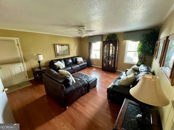 a bedroom with a bed a mirror on dresser and a wooden floor