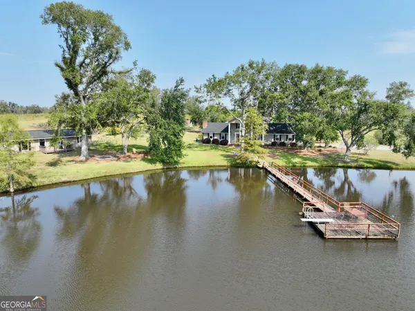 a view of a lake with a floor to ceiling window and potted plants