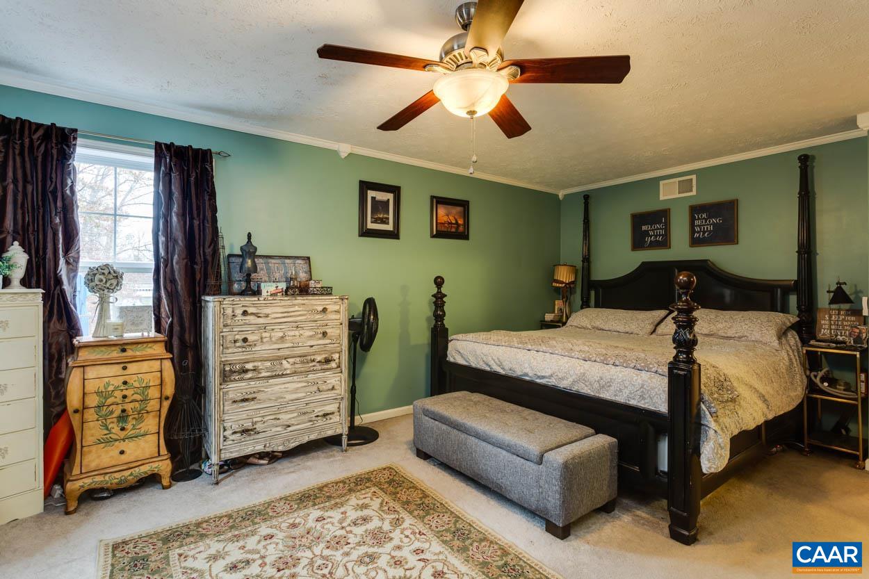 39 Paynes Mill Road Troy, VA 22974 - Photo 21 of 54 a bedroom with a bed a dresser and a chandelier