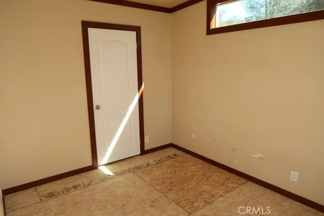 a view of a small space with wooden floor and a window