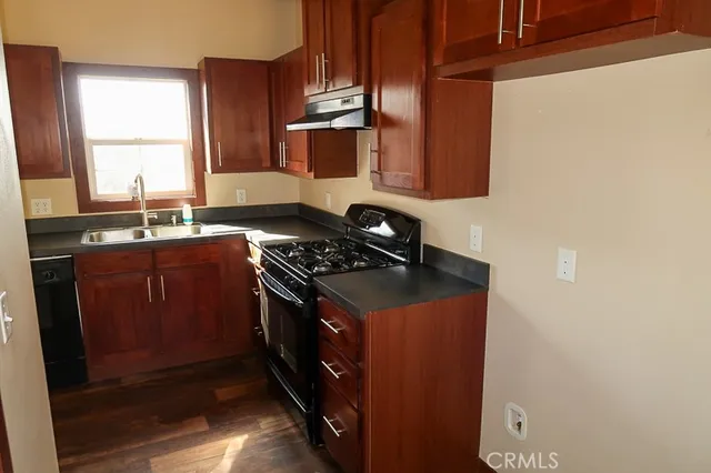 a kitchen with stainless steel appliances granite countertop a sink stove and cabinets