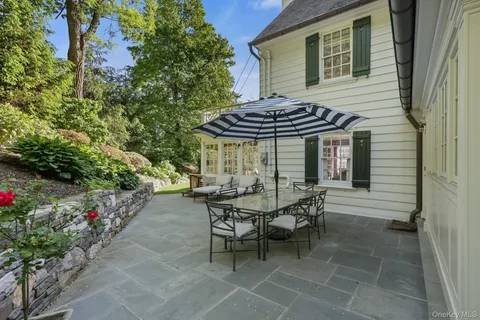a view of a patio with a table and chairs under an umbrella
