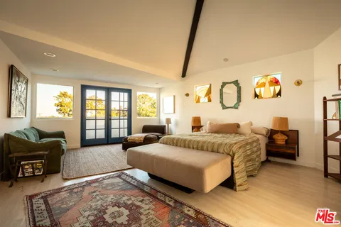 a spacious bedroom with a bed couch and a window