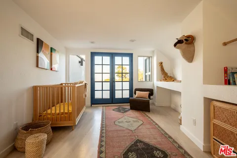 a bedroom with a bed and wooden floor