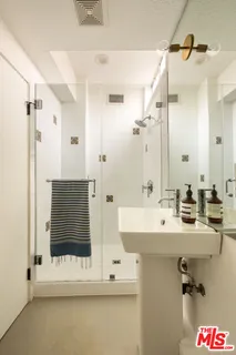 a bathroom with a double vanity sink mirror and shower