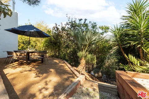 a view of a backyard with plants and a patio