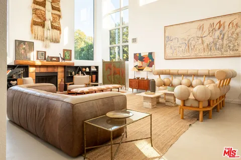 a living room with furniture and a floor to ceiling window