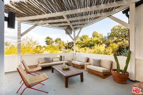 a roof deck with couches and potted plants