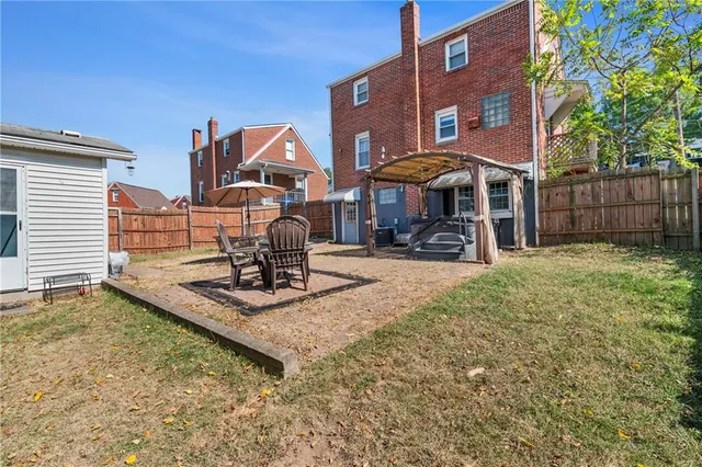 a view of a house with backyard and sitting area