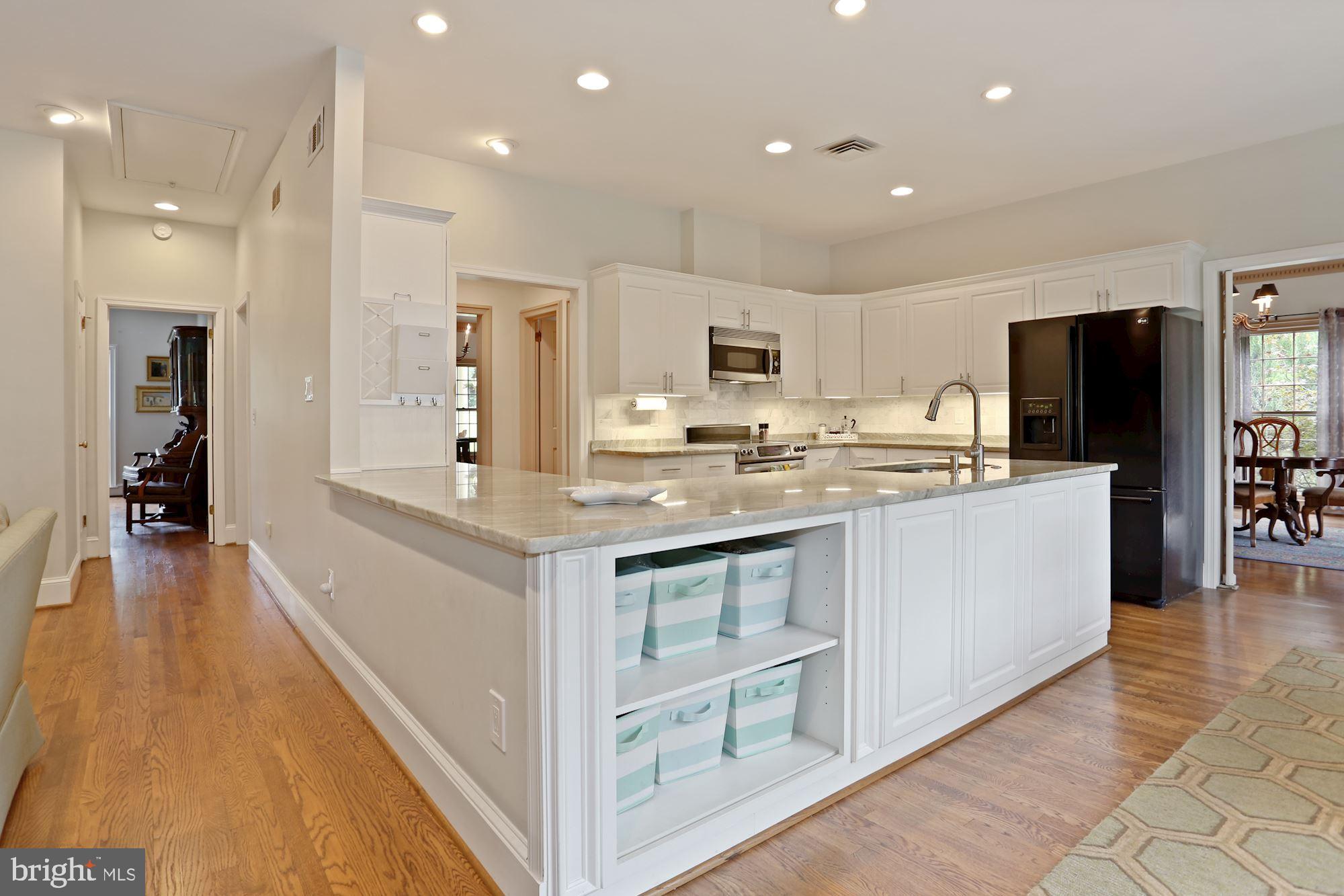1311 Merrie Ridge Road McLean, VA 22101 - Photo 14 of 54 a kitchen with kitchen island granite countertop a stove top oven a sink a refrigerator and white cabinets with wooden floor