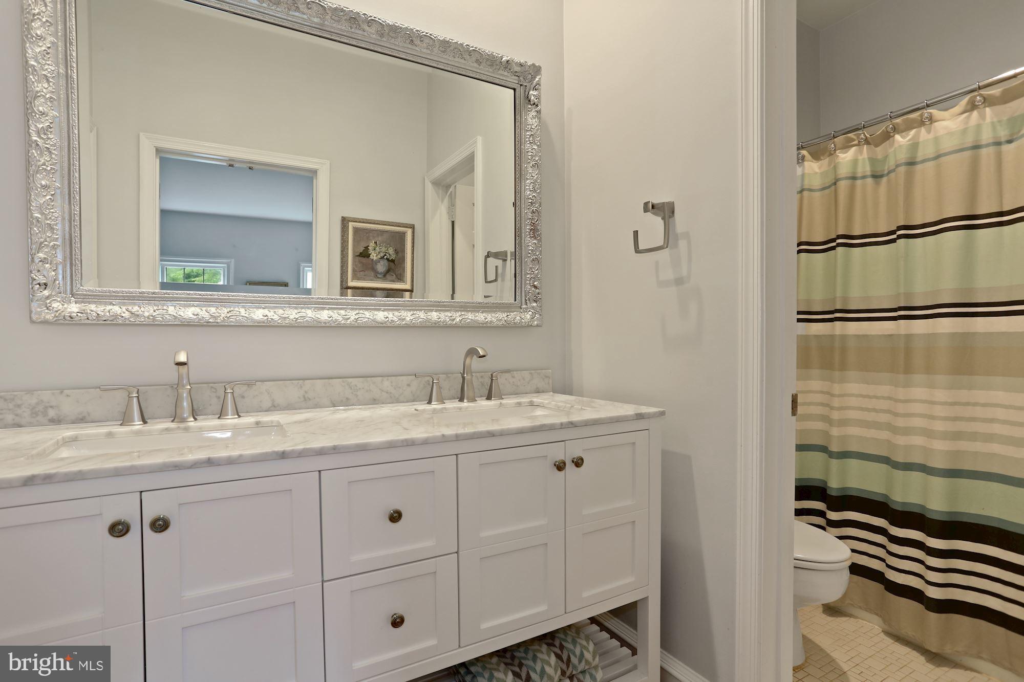 1311 Merrie Ridge Road McLean, VA 22101 - Photo 22 of 54 a bathroom with a granite countertop sink and a mirror