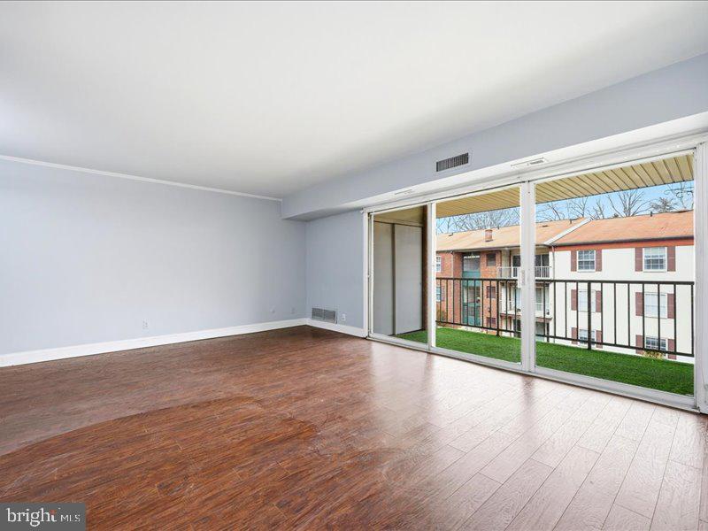 421 Drummers Lane, Unit 421 Wayne, PA 19087 - Photo 5 of 30 wooden floor in an empty room with a window