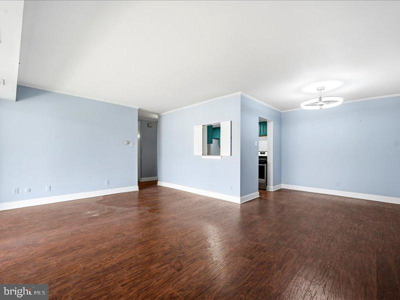 421 Drummers Lane, Unit 421 Wayne, PA 19087 - Photo 6 of 30 a view of an empty room with wooden floor and a window