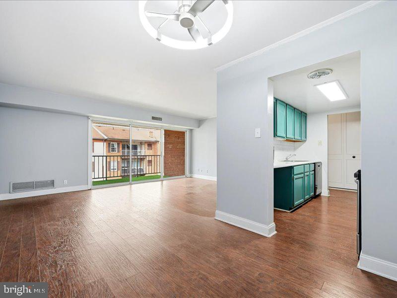 421 Drummers Lane, Unit 421 Wayne, PA 19087 - Photo 7 of 30 an empty room with wooden floor cabinet and windows