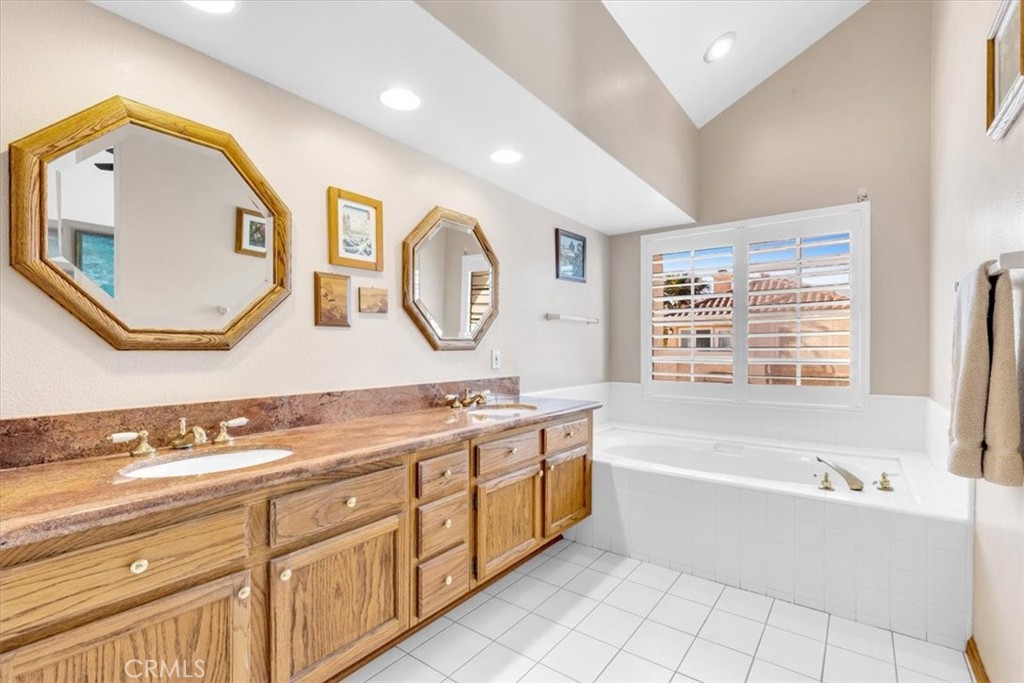 10 St John Dana Point, CA 92629 - Photo 12 of 31 a bathroom with a bathtub a mirror a vanity and a sink