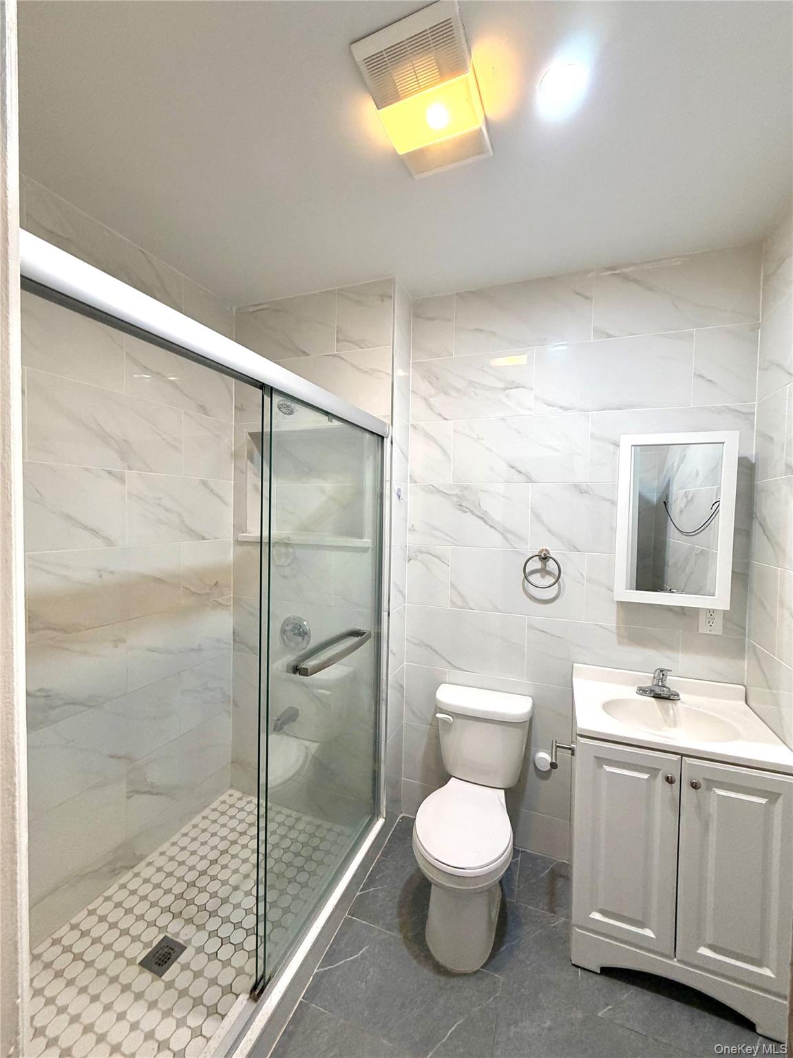 30-06 85th Street, Unit 2 Queens, NY 11370 - Photo 4 of 7 Bathroom with tile walls, vanity, and a shower stall