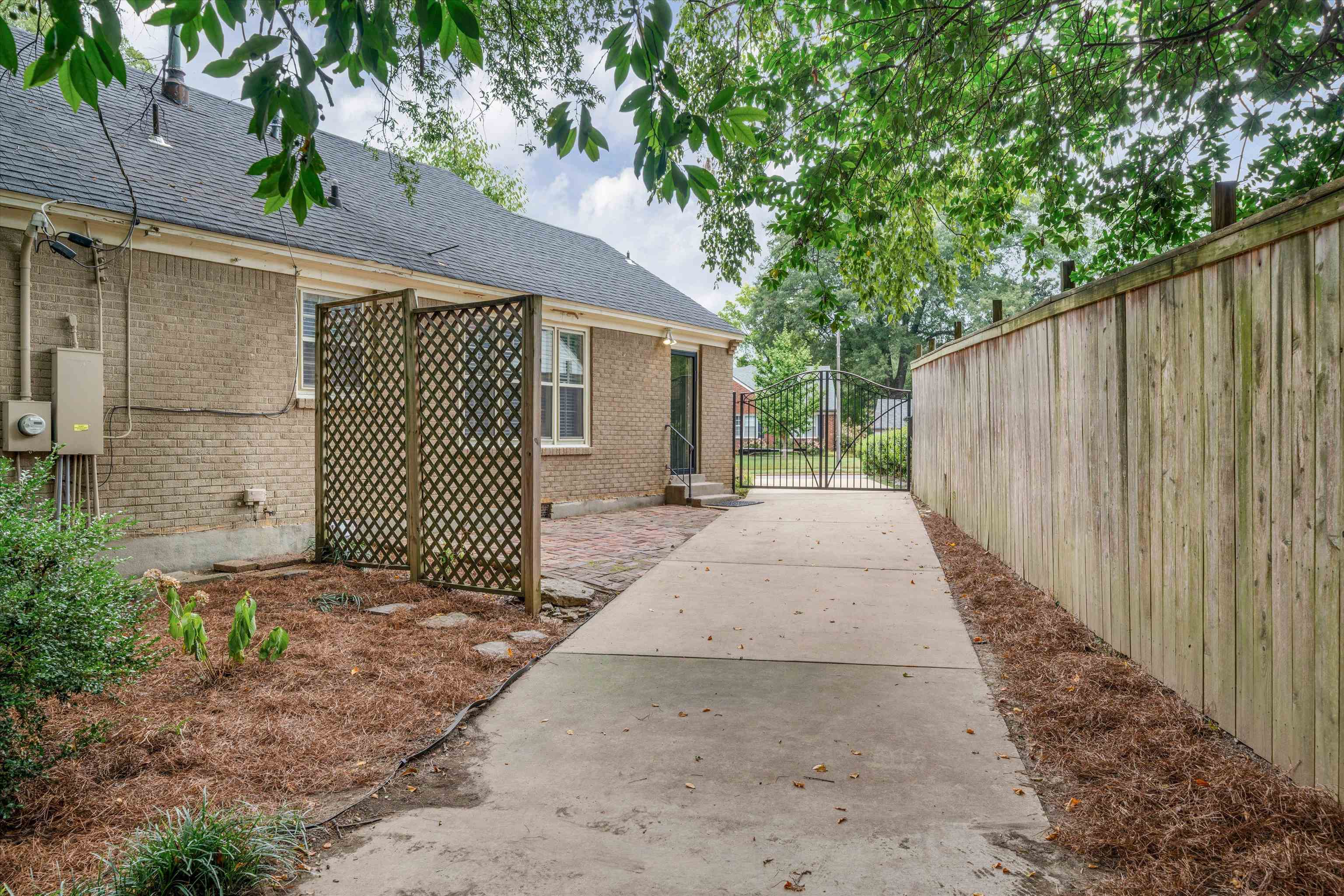 17 North Ashlawn Road Memphis, TN 38112 - Photo 25 of 28 View of side of home featuring a shingled roof, brick siding, and a gate