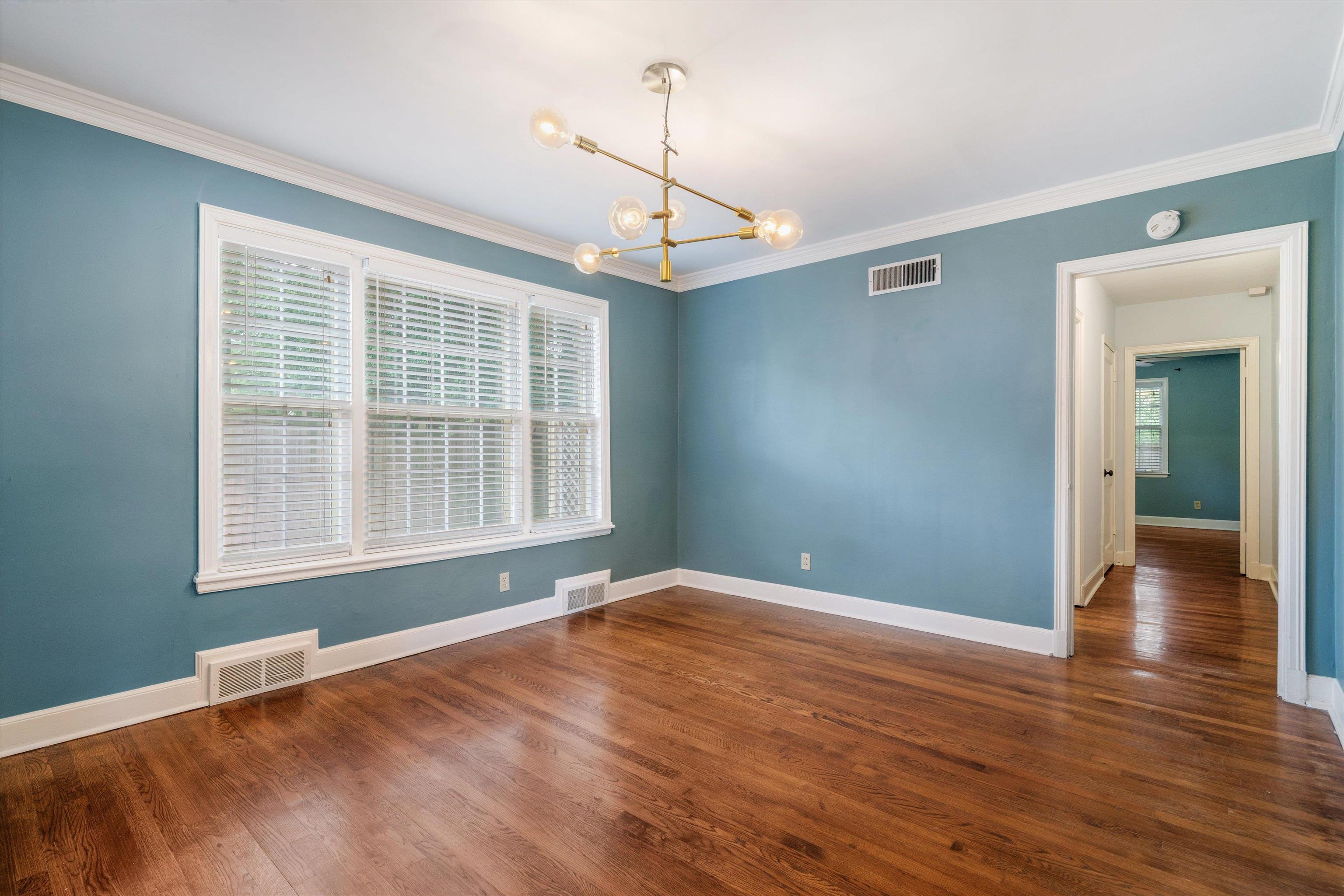17 North Ashlawn Road Memphis, TN 38112 - Photo 7 of 28 Spare room featuring a chandelier, dark wood-type flooring, and crown molding