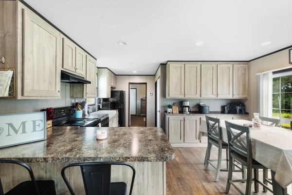 148 A Rogers Road New Waverly, TX 77358 - Photo 14 of 31 a kitchen with kitchen island granite countertop a table chairs microwave and cabinets