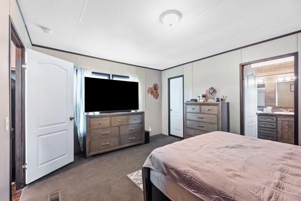 148 A Rogers Road New Waverly, TX 77358 - Photo 16 of 31 a bedroom with a bed and a flat screen tv