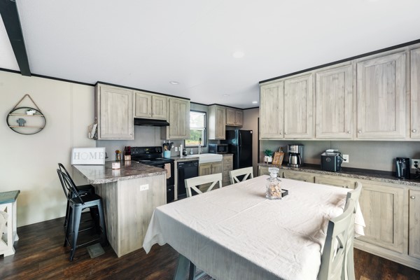148 A Rogers Road New Waverly, TX 77358 - Photo 4 of 31 a kitchen with a table chairs a sink dishwasher and cabinets