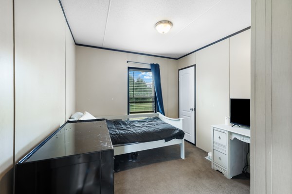 148 A Rogers Road New Waverly, TX 77358 - Photo 7 of 31 a bedroom with a bed and flat tv screen on the table