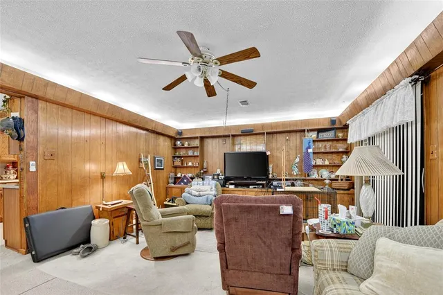 a living room with furniture a flat screen tv and a window