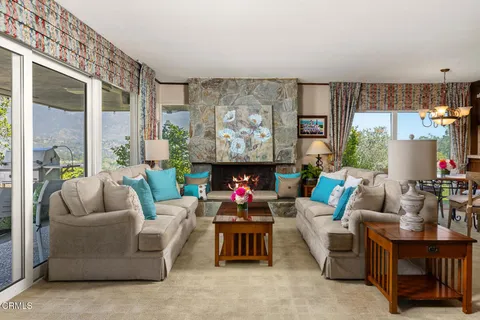 a living room with fireplace furniture and a large window