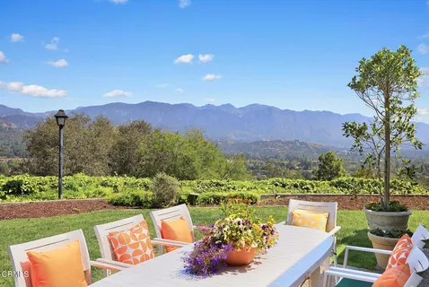 a view of a patio with a table and chairs under an umbrella