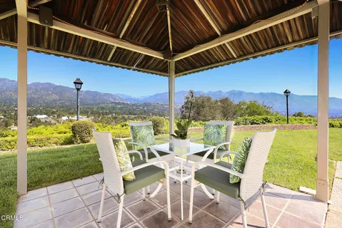 a view of a house with backyard and sitting area