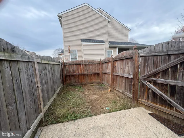 a view of backyard with small cabin and wooden fence