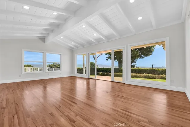 a view of an empty room with window wooden floor and fire place