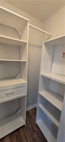 a view of walk in closet with empty racks