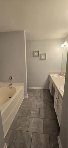 a spacious bathroom with a tub sink and mirror