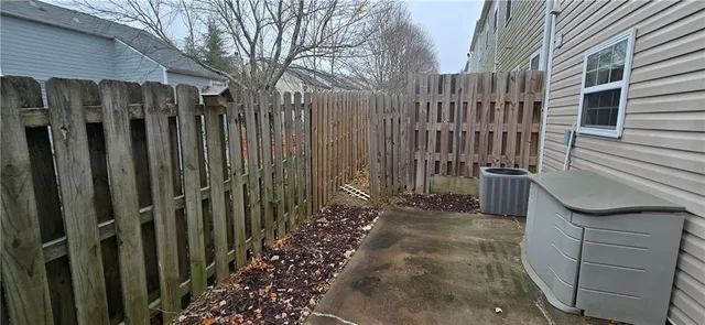 a view of a pathway of a house with wooden fence