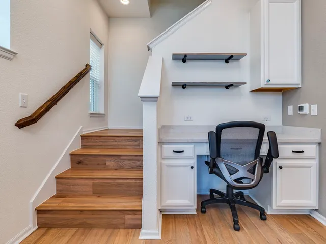 a view of a hallway with wooden floor and staircase
