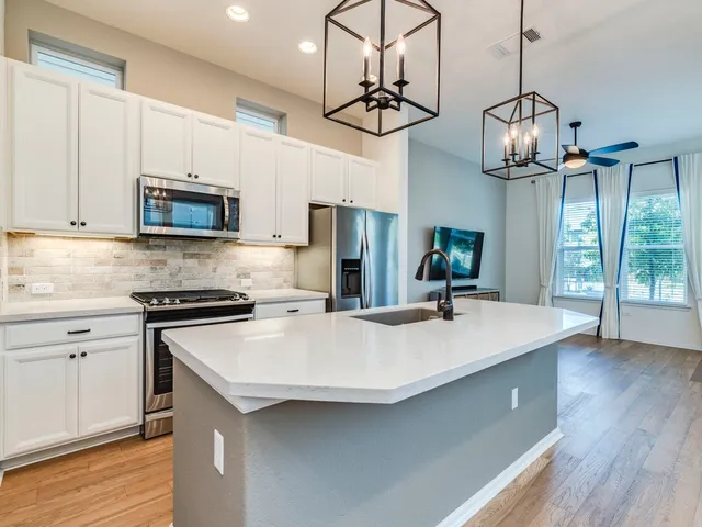 a kitchen with a stove a microwave and wooden floor