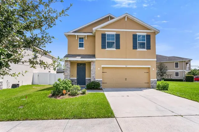 a front view of a house with a yard and garage
