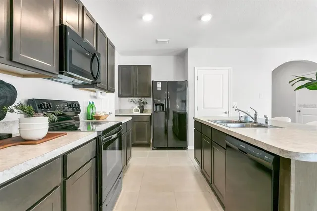 a kitchen with stainless steel appliances granite countertop a sink a stove and a refrigerator