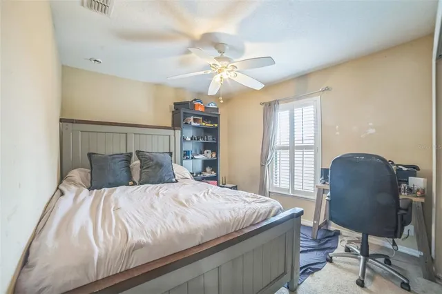 a bedroom with a bed desk and a window