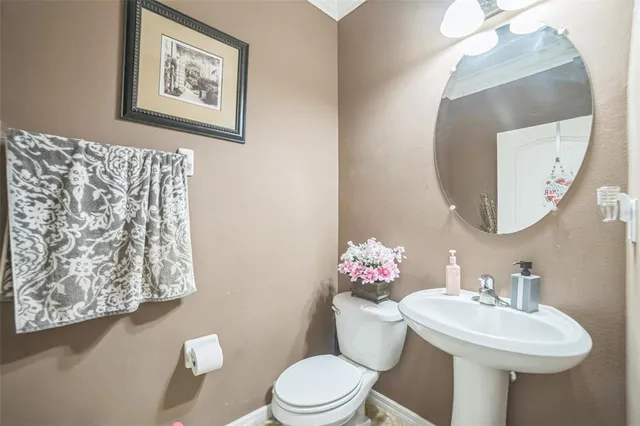 a bathroom with a sink mirror and toilet