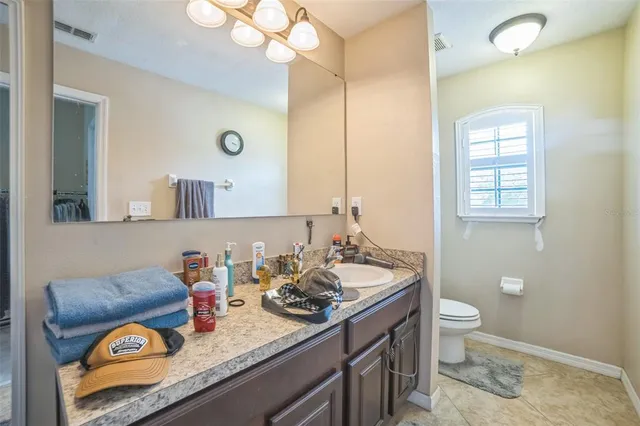a bathroom with a granite countertop sink a toilet and a mirror