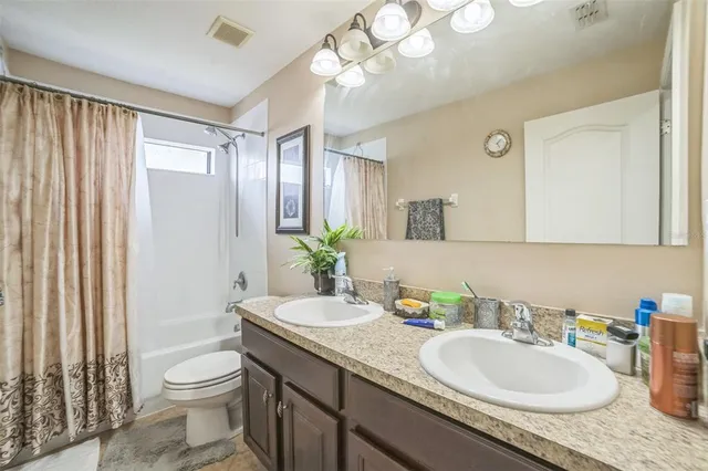 a bathroom with a granite countertop sink a toilet and a mirror