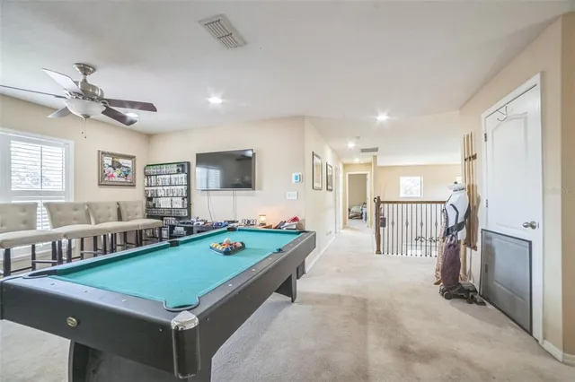 a living room with furniture pool table and chairs