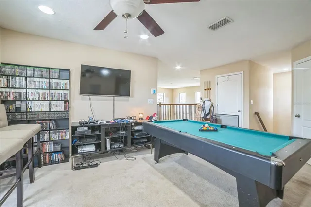 a living room with furniture a flat screen tv and kitchen view