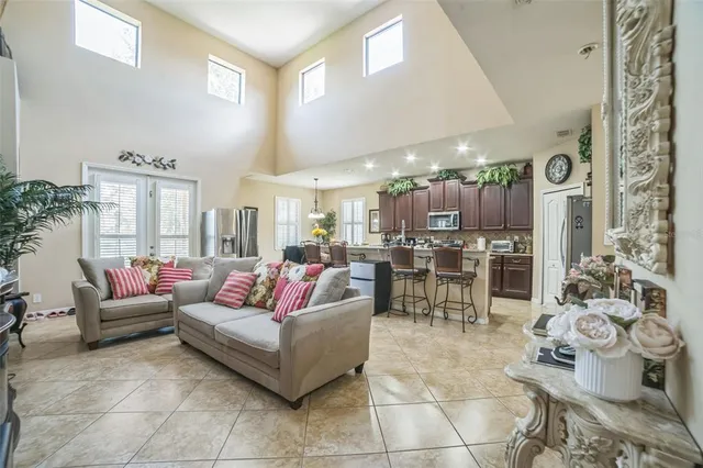 a living room with couches and kitchen view with wooden floor