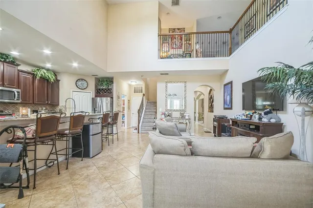 a living room with furniture kitchen view and a large window
