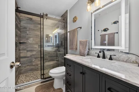 a bathroom with a granite countertop sink toilet and shower