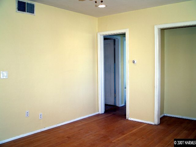 1065 Locust Street Reno, NV 89502 - Photo 2 of 6 a view of an empty room with wooden floor and a window